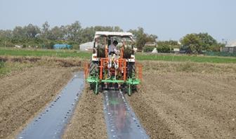 Tractor operated drip lateral and plastic mulch layer cum-planter